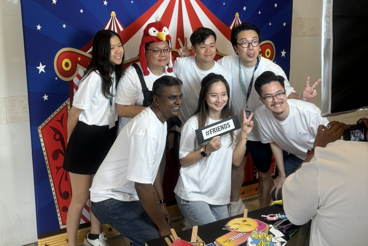 Guests posing with props at a carnival-themed photo wall