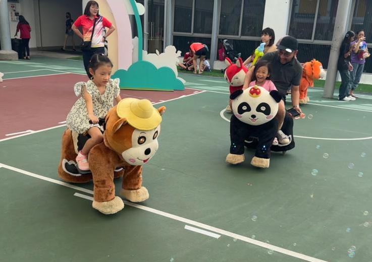 Children riding plush animal kiddie rides